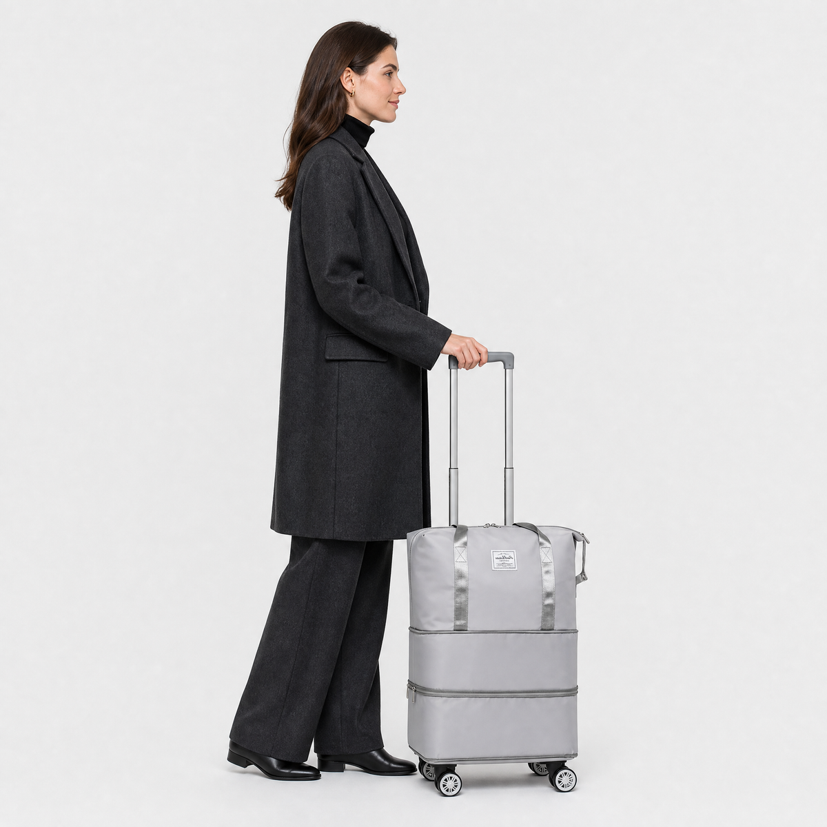 Sac de Voyage Femme à Roulettes, coloris Gris, porté par un mannequin